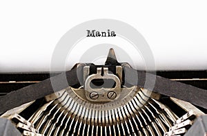 The word `Mania` from a typewriter on white photo