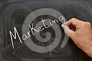 The word marketing written with a chalk on the blackboard