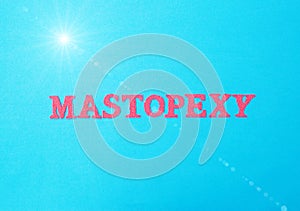 The word mastopexy in red letters on a blue background. The concept of aesthetic surgery in changing ptosis of the mammary gland.