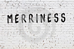 Word merriness painted on white brick wall photo
