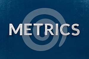 The word metrics laid with silver metal letters on classic blue surface photo