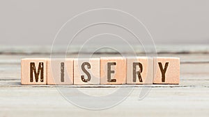 Word Misery on wood cubes photo