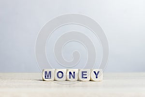 A word `Money` on a wooden table over the light wall