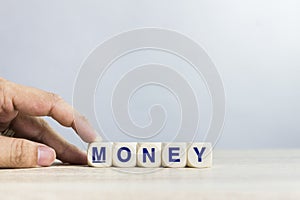A word `Money` on a wooden table over the light wall