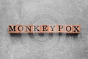 Word Monkeypox made of wooden cubes on light grey background, top view