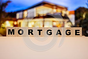 The word MORTGAGE on the background of a dream, a personal home. Loan repayment difficulties