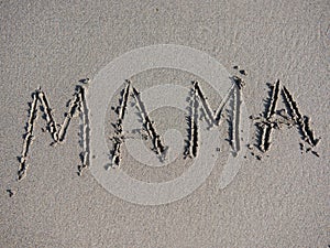 Word mother is written on the sand