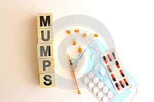 The word MUMPS is made of wooden cubes on a white background. Medical concept