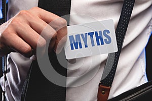 The word myths young man holding blank card against white background with vignette