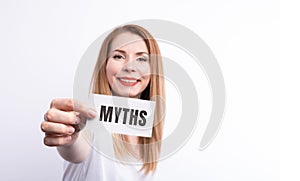 The word myths young woman holding blank card against white background with vignette