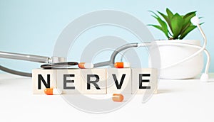 The word NERVE is written on wooden cubes near a stethoscope on a wooden background. Medical concept