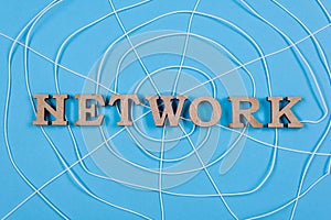 The word network with wooden letters in the form of an abstract spider web, blue background