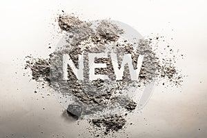 Word new written in ash, dust, dirt as a irony, oxymoron, paradox concept for old, news, business, sale, death, life, future, adv photo