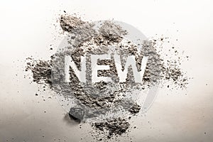 Word new written in ash, dust, dirt as a irony, oxymoron, paradox concept for old, news, business, sale, death, life, future, adv