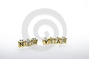 The word - New Year in the English alphabet made from yellow gold cubes on white. Christmas holidays concept. 2021 happy new year