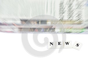 The word NEWS with abstract newspaper on white background.