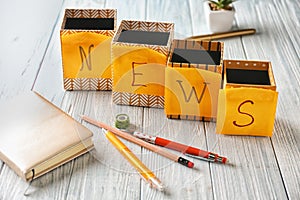 Word NEWS made with sticky notes on wooden table