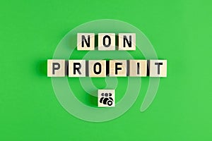 The word non profit written on wooden cubes with people icon on green background