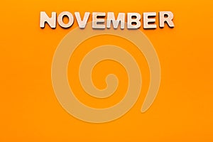 Word November on orange background