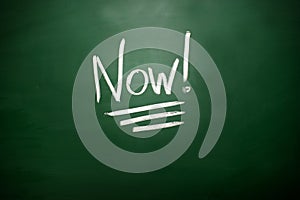 The word Now! on blackboard. A time management concept