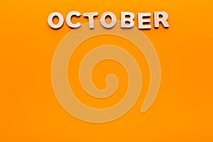 Word October on orange background photo