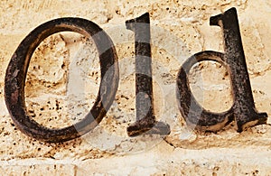 The word old in metal letters on stone background