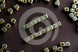 Word ONLINE MARKETING made from small golden letters on the brow