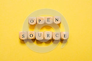 the word Open Source, text made with dice on yellow background