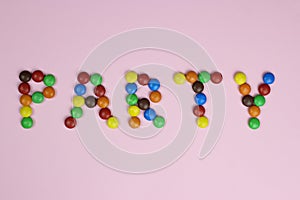 Word party of colored candies on a pink background