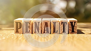 Word PENALTY made with building wooden blocks on table in sunlight