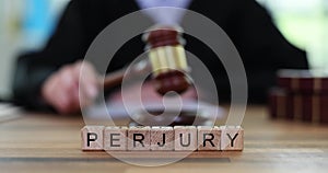 Word Perjury constructed from wooden cubes against judge