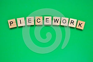 Word piecework. Top view of wooden blocks with letters on green surface