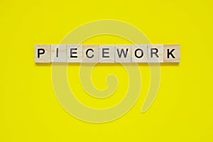 Word piecework. Top view of wooden blocks with letters on yellow surface