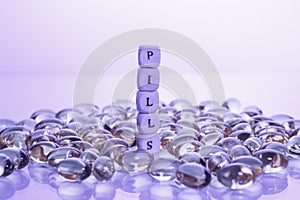 Word pills from the letters of cubes and Lecithin gel pills on light background