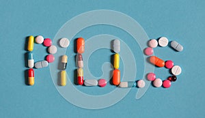 Word Pills Is Lined With Colored Pills And Tablets On A Blue Background