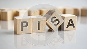 word Pisa on wooden cubes, gray background photo