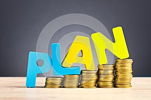 word PLAN and stacking coins on wooden desk over beautiful reverberation gradient background