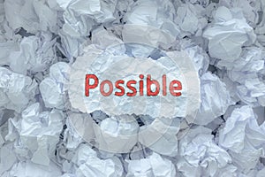 The word  POSSIBLE is placed on the background paper in the big trash