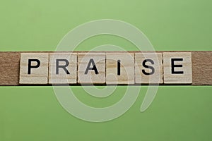 word praise made of small gray wooden letters