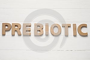 Word Prebiotic made of letters on white wooden table, top view