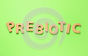 Word Prebiotic made of wooden letters on light green background, top view