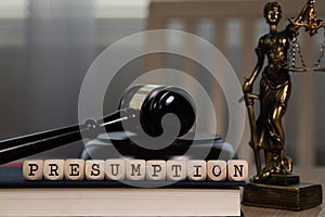 Word PRESUMPTION composed of wooden dices. Wooden gavel and statue of Themis in the background