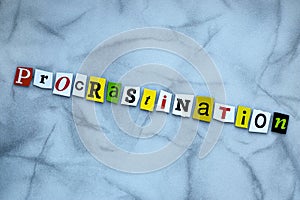 Word procrastination of cut letters on gray background. Psychologic concept. Headline - procrastination. A word writing text procr photo