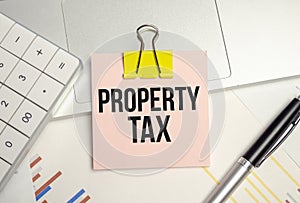 the word Property Tax is written in a notebook and calculator