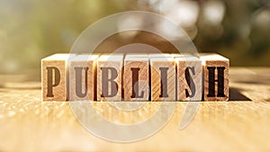 Word PUBLISH on wooden cubes on light background