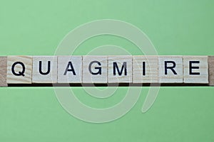 word quagmire made of small gray wooden letters photo
