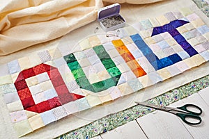 The word quilt sewn from colorful square and triangle pieces of fabric