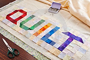 The word quilt sewn from colorful square and triangle pieces of fabric