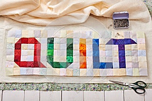 The word quilt sewn from colorful square and triangle pieces of fabric