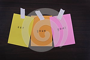 Word quotes of set your goal on sticky color papers
